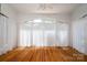 Bright sunroom with hardwood floors and large window with semi-sheer white curtains at 418 3Rd Ne St, Hickory, NC 28601