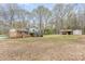 Expansive backyard with a brick house, wooden deck, and storage sheds at 4603 Oakwood Cir, Gastonia, NC 28056
