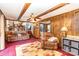 Cozy living room featuring paneled walls, wood beams, comfortable seating, and warm lighting at 4603 Oakwood Cir, Gastonia, NC 28056