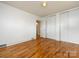 Bright bedroom featuring hardwood floors, white walls, and closet with sliding doors at 4625 Woodlark Ln, Charlotte, NC 28211