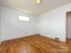Cozy bedroom featuring hardwood floors, neutral walls, and a large window for natural light at 4625 Woodlark Ln, Charlotte, NC 28211