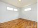 Inviting bedroom featuring hardwood floors, two windows providing natural light, and freshly painted white walls at 4625 Woodlark Ln, Charlotte, NC 28211