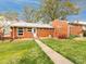Red brick home featuring a well-manicured lawn and inviting walkway to the front entrance at 4625 Woodlark Ln, Charlotte, NC 28211