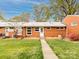 Charming red brick home with a well-maintained lawn and inviting walkway to the front door at 4625 Woodlark Ln, Charlotte, NC 28211