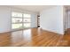 Inviting living room with gleaming hardwood floors, white walls, and a large window for natural light at 4625 Woodlark Ln, Charlotte, NC 28211