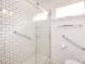 Modern shower with subway tile, grab bars, and glass door at 4625 Woodlark Ln, Charlotte, NC 28211