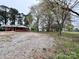 Gravel backyard of home, with mature shade trees at 511 W Main St, Cleveland, NC 27013