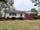 Charming single-story home featuring a brick and white siding exterior with a cozy front porch and landscaped yard at 511 W Main St, Cleveland, NC 27013