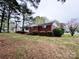 Side view of the home, highlighting the brick exterior and landscaped surroundings on a lush lawn at 511 W Main St, Cleveland, NC 27013