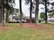 View of the home and expansive front yard, framed by mature trees and greenery, creating a serene setting at 511 W Main St, Cleveland, NC 27013