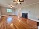 Spacious living room with hardwood floors, a fireplace, and two ceiling fans, offering comfort and style at 511 W Main St, Cleveland, NC 27013