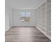 Bright living room with built-in shelving, wood-look flooring, and a large window at 5680 Gold Creek Bay None, Hickory, NC 28601