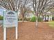Community clubhouse sign nestled amongst mature trees, showing well-manicured lawns and inviting entrance at 6225 Woodleigh Oaks Dr, Charlotte, NC 28226