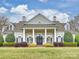 Stately home with a columned entrance, manicured shrubs, and a sprawling lawn, offering curb appeal at 6225 Woodleigh Oaks Dr, Charlotte, NC 28226