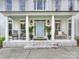 Inviting front porch with a baby blue door, white columns, and rocking chairs at 6225 Woodleigh Oaks Dr, Charlotte, NC 28226