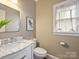 Elegant powder room with marble vanity, stylish mirror, and fresh, neutral paint at 6225 Woodleigh Oaks Dr, Charlotte, NC 28226