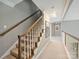 Elegant stairway with wooden railing and neutral carpeting at 6225 Woodleigh Oaks Dr, Charlotte, NC 28226