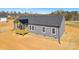 Home featuring gray siding, a dark roof, and a charming, covered front porch, set on a spacious lot at 629 Mt. Wesley Church Rd, Hiddenite, NC 28636