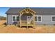 New construction home with gray siding, dark roof, and a charming, covered front porch with wooden detail at 629 Mt. Wesley Church Rd, Hiddenite, NC 28636