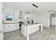 Bright, airy kitchen with white cabinets, stainless steel appliances, an island, and ample counter space at 629 Mt. Wesley Church Rd, Hiddenite, NC 28636
