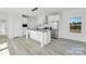 Bright kitchen features white cabinets, stainless steel appliances, and a large center island with a stone countertop at 629 Mt. Wesley Church Rd, Hiddenite, NC 28636