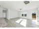 Bright and airy living room featuring wood-look floors, a ceiling fan, and natural light from two windows at 629 Mt. Wesley Church Rd, Hiddenite, NC 28636