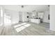 Open floor plan with kitchen island and stainless appliances, featuring wood-look floors and recessed lighting at 629 Mt. Wesley Church Rd, Hiddenite, NC 28636