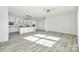 Open floor plan with kitchen island and stainless appliances, featuring wood-look floors and recessed lighting at 629 Mt. Wesley Church Rd, Hiddenite, NC 28636