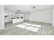 Open floor plan with kitchen island and stainless appliances, featuring wood-look floors and recessed lighting at 629 Mt. Wesley Church Rd, Hiddenite, NC 28636