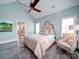 Light-filled bedroom with tufted headboard, stylish chair, and access to spa-like bathroom at 630 Deese Rd, Monroe, NC 28110