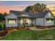 Beautiful home exterior with manicured lawn, landscaping, and a charming covered front porch at sunset at 630 Deese Rd, Monroe, NC 28110