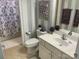 Well-lit bathroom featuring striped wallpaper, modern sink, and shower with patterned curtain at 637 Williamson Rd # 304, Mooresville, NC 28117