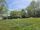 View of a large grassy yard with a few homes on the horizon at 637 Williamson Rd # 304, Mooresville, NC 28117