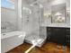 Bright bathroom featuring a standalone tub and a glass enclosed shower with marble walls and chrome hardware at 6700 Folger Dr, Charlotte, NC 28270