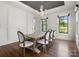 Formal dining room with paneled walls, hardwood floors, a modern chandelier, and large windows at 6700 Folger Dr, Charlotte, NC 28270