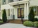 Elegant home entrance featuring a brick staircase, black framed door, and white pillars at 6700 Folger Dr, Charlotte, NC 28270