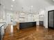 Spacious kitchen with white cabinets, a large center island, stainless steel appliances, and hardwood floors at 6700 Folger Dr, Charlotte, NC 28270