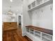 View of the mudroom with a wooden bench with white cubbies and a view of the kitchen with an island at 6700 Folger Dr, Charlotte, NC 28270