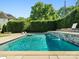 Beautiful in-ground pool features stone accents, landscaping, and patio area, perfect for outdoor enjoyment at 6700 Folger Dr, Charlotte, NC 28270