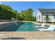 A backyard pool area provides a relaxing outdoor living space with in-pool seating and mature landscaping at 6700 Folger Dr, Charlotte, NC 28270