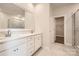 Bathroom featuring double sinks, white cabinets, a glass-enclosed shower, and marble-look flooring at 7009 New Town Rd, Waxhaw, NC 28173