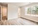 Light-filled bedroom with wood-look floors, an en-suite bathroom and natural light from a large window at 7009 New Town Rd, Waxhaw, NC 28173