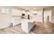 Bright kitchen with white cabinets, a large center island, stainless steel appliances, and wood-look flooring at 7009 New Town Rd, Waxhaw, NC 28173
