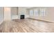 Spacious living room featuring a fireplace, built-in cabinets, three large windows, and stylish flooring at 7009 New Town Rd, Waxhaw, NC 28173