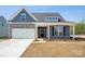Charming single-Gathering home featuring a stone facade, white garage door, and inviting front porch at 896 Exeter Dr, Sherrills Ford, NC 28673
