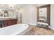 Bathroom boasts a soaking tub with granite surround and a large framed mirror at 9011 Pine Laurel Dr, Weddington, NC 28104