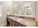Bathroom vanity featuring a granite countertop, wooden cabinets, and large mirror at 9011 Pine Laurel Dr, Weddington, NC 28104