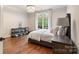 Bedroom featuring hardwood floors, natural light, and stylish furniture at 9011 Pine Laurel Dr, Weddington, NC 28104