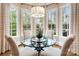 Sun-filled breakfast nook features a glass table with seating and many windows at 9011 Pine Laurel Dr, Weddington, NC 28104