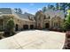 Stone home featuring a circular driveway and three car garage at 9011 Pine Laurel Dr, Weddington, NC 28104